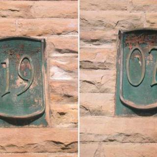 Engraved stone plaques displaying the year 1907 on a building facade.