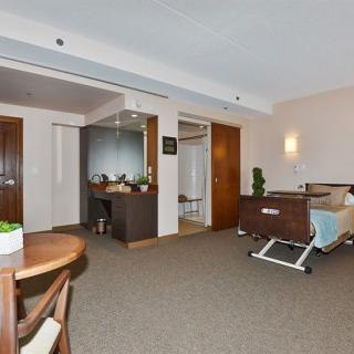 A clean and modern hospital room with a bed and seating area.