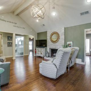 A spacious living room with high ceilings, featuring a fireplace and stylish furniture.