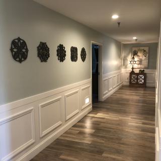 A beautifully decorated hallway with wall art and wooden flooring.
