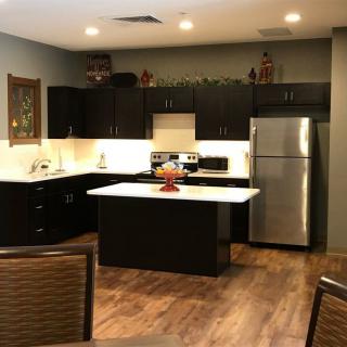 Modern kitchen with dark cabinets and stainless steel appliances.