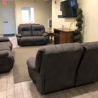 A comfortable living room with multiple sofas and a wall-mounted television.