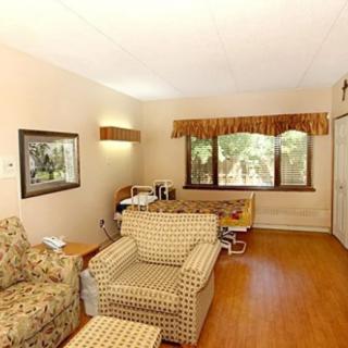 A cozy living room with patterned furniture and a large window offering a scenic view.