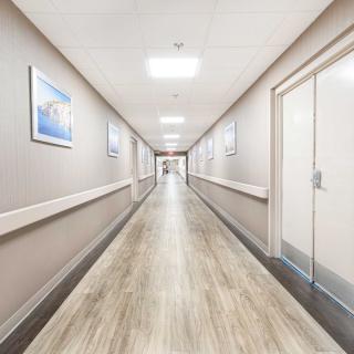 A clean, modern hospital corridor with bright lighting and artwork on the walls.