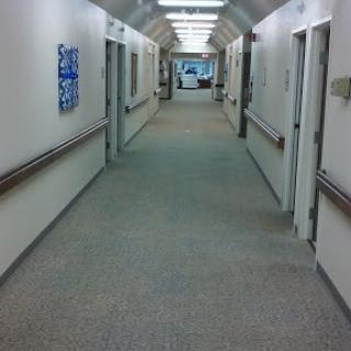 A clean and well-lit hospital hallway lined with doors.