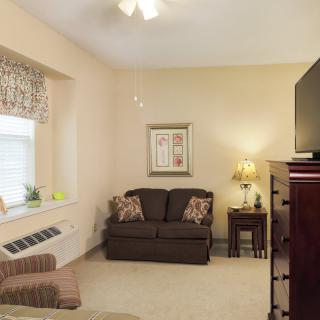 A cozy living room with a sofa, TV, and elegant decor.