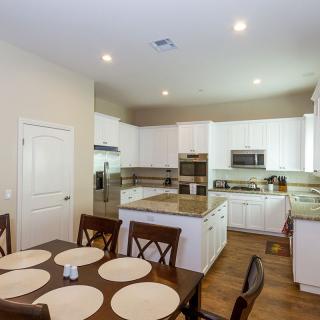 A modern kitchen and dining area featuring white cabinets and a central island.