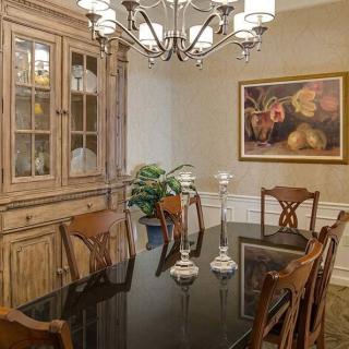 A classic dining room with wooden furniture and a chandelier.