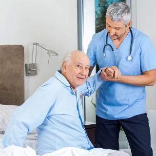 A nurse assisting an elderly patient in a hospital setting.