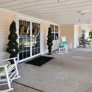 A cozy porch with rocking chairs and decorative plants at the entrance.