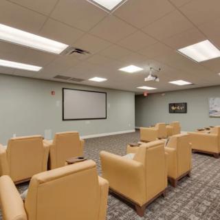 A cozy home theater setup with comfortable seating and a large screen for viewing.