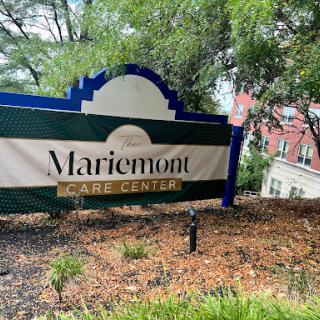 A sign for Mariemont Care Center surrounded by greenery.