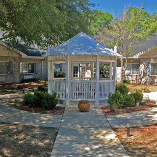 A charming courtyard with a central gazebo surrounded by well-maintained pathways and greenery.