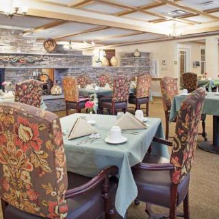 An elegantly decorated dining area with neatly arranged tables and floral-patterned chairs.