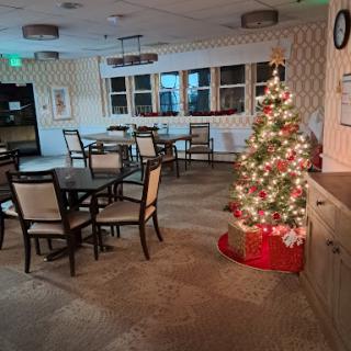 A cozy dining area decorated for the holidays, featuring a beautifully lit Christmas tree.