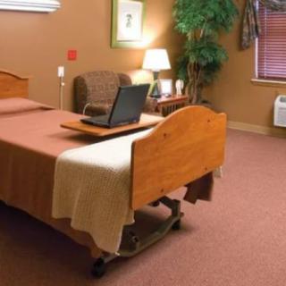 A hospital room with a bed, a chair, and other furniture.
