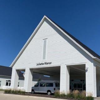 A contemporary white building with a peaked roof and clear blue sky.