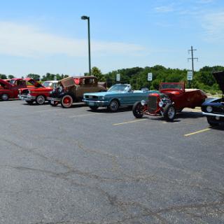 A lineup of classic and vintage cars parked at a local car show.