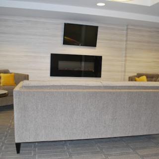 A modern lounge area featuring comfortable sofas, a wall-mounted television, and an elegant fireplace.