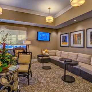 A modern lounge area featuring comfortable seating, tasteful artwork, and ambient lighting.