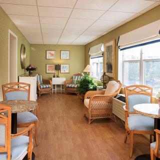 A cozy seating area with wicker chairs and natural lighting from large windows.