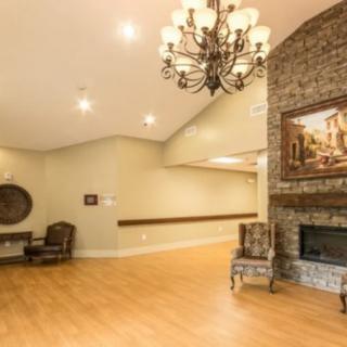 A well-lit lobby featuring a chandelier, fireplace, and comfortable seating.