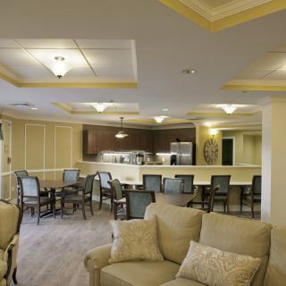 A spacious and well-lit living area with seating and an open kitchen.
