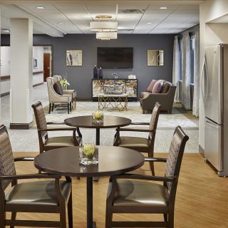 A modern lounge area with tables and chairs, featuring a comfortable seating arrangement and stylish decor.