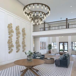 A spacious lobby featuring modern furniture and a large chandelier.