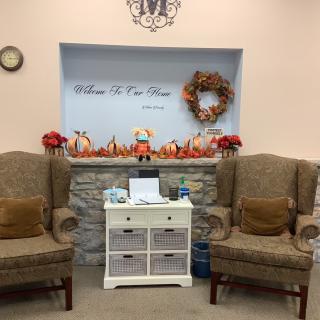 A cozy waiting room with fall-themed decorations and seating.