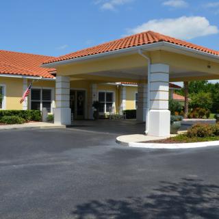 A building with a covered entrance and landscaped surroundings.