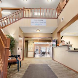 A bright lobby area with a staircase and reception desk.