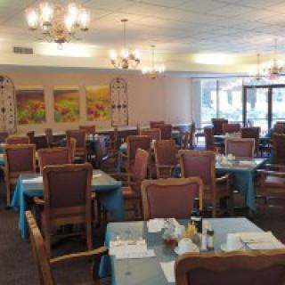 A well-lit restaurant dining area with neatly arranged tables and chairs.