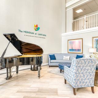 A chic and modern lobby featuring a grand piano and comfortable seating areas.