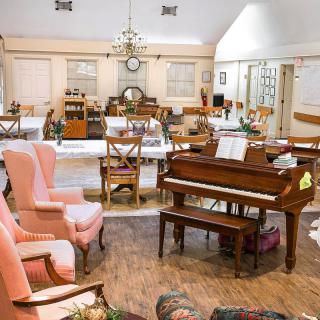 A cozy living room featuring a piano and comfortable seating.