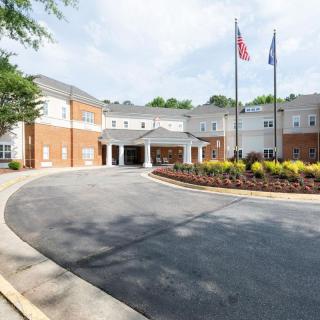 A beautiful building with an entrance driveway and flags displayed at the front.