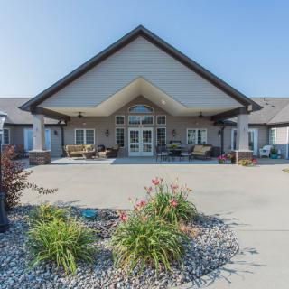 A well-maintained building entrance with landscaped surroundings and a paved walkway.