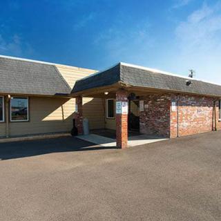 Exterior view of a motel entrance with brick and siding design.