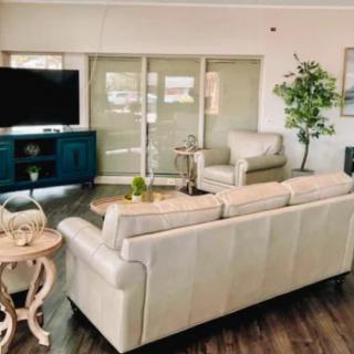 A cozy living room featuring a comfortable sofa, an armchair, a TV, and stylish decor.