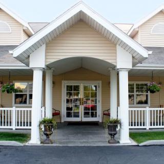 A residential building entrance with a porch and columns.