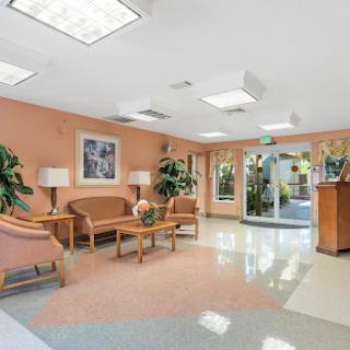 A bright and inviting lobby featuring comfortable seating and green plants.