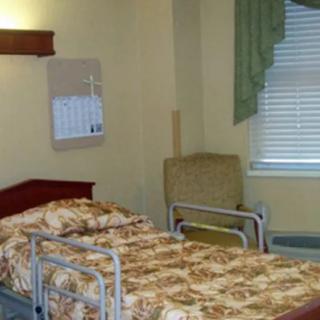 A simple hospital room with a single bed and window.