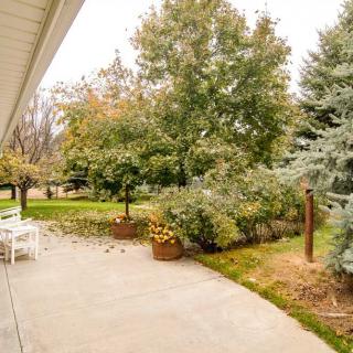 A serene backyard patio surrounded by lush trees and landscaping, capturing the essence of fall.