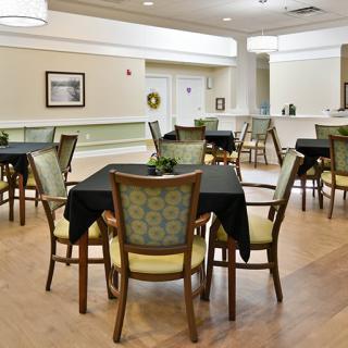 A well-lit dining area with neatly arranged tables and chairs, featuring modern decor.