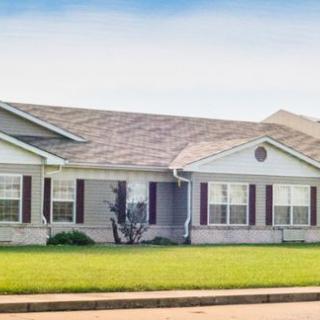 A single-story suburban house with a well-maintained lawn.