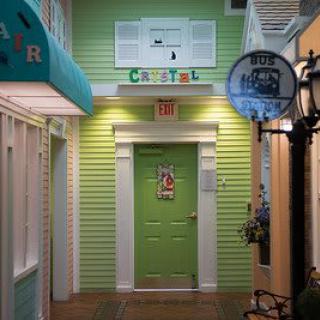 A colorful indoor hallway featuring a green door with decorative elements.