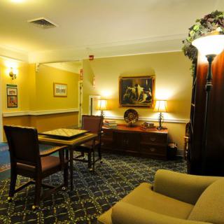 A cozy lounge area with comfortable seating, artwork on the walls, and warm lighting.