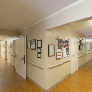 A hallway interior with multiple doors and a bulletin board on the wall.