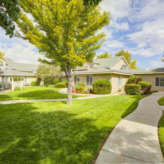 A peaceful suburban neighborhood with well-maintained lawns and trees lining the pathways.