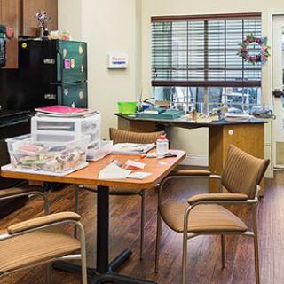 A cluttered kitchen interior with a table and chairs.